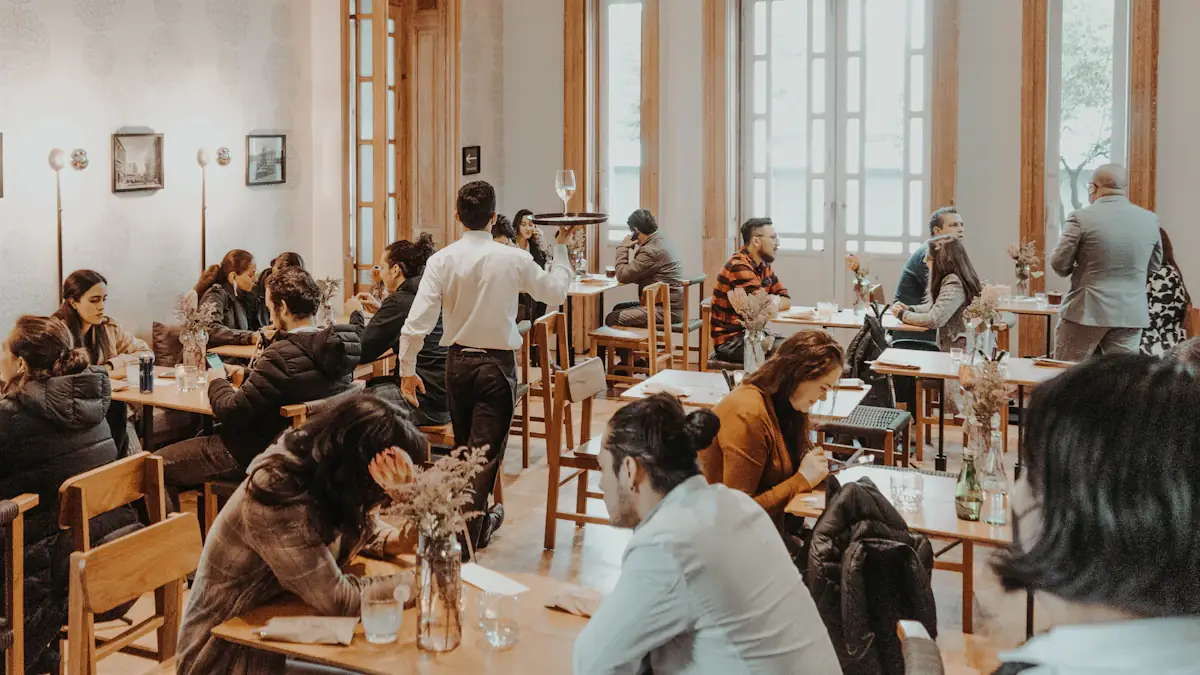 Salle de restaurant pleine en plein service, un serveur traverse la salle avec un plateau
