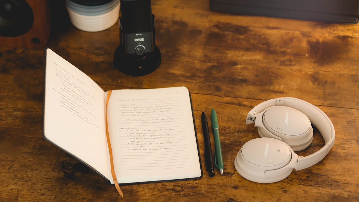 Carnet ouvert avec des notes manuscrites, deux stylos et un casque