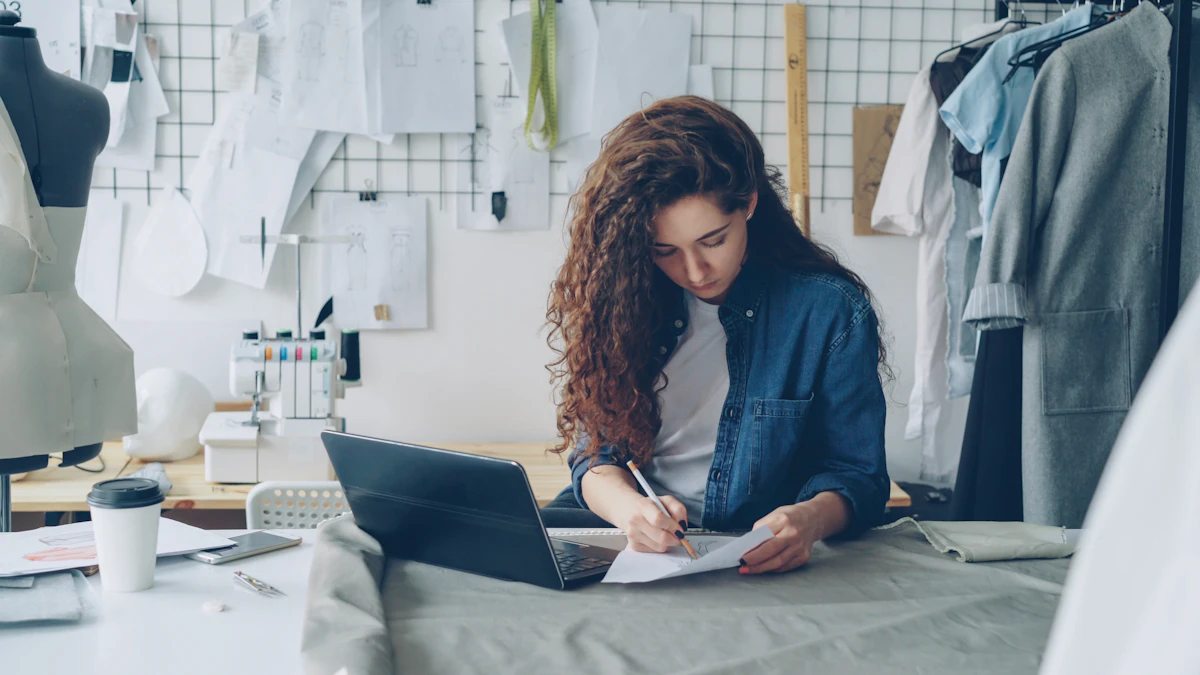 Femme écrivant sur un document près d'un ordinateur portable dans son atelier
